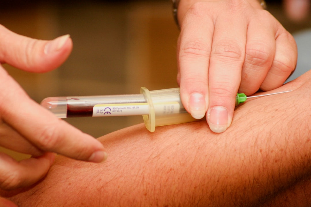Medical professional drawing blood from a patient's arm.